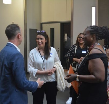 students speaking with professor at graduation
